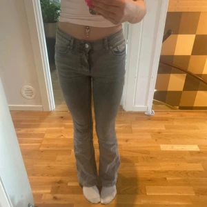Grå bootcut jeans från Perfect Jeans - Säljer ett par gråa jeans från Perfect Jeans med bootcut-passform. Jeansen har klassisk femficksdesign, knapp- och dragkedjegylf. Dem har en slitning vid knät (bild 3). Perfekta för dig som gillar en tidlös look med lite extra edge. Jag är 162 cm. Köpta för 600 kr 