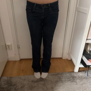 Mörkblå Levis jeans med bootcut fit - Säljer ett par klassiska mörkblå Levis jeans med bootcut passform och låg midja. Jeansen har fem fickor, dragkedja och knapp framtill samt Levis-logga på bakfickan. Perfekta till vardags och passar till det mesta.