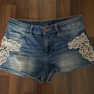 Blå jeansshorts med spetsdetaljer - Snygga shorts i storlek S säljs för att dom inte passar mig så bra 