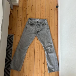 HOPE RUSH - Säljer ett par grå jeans från HOPE i storlek 31 med klassisk femficksdesign och raka ben. Jeansen är något bootcut i designen och är tillverkade i ett robust jeanstyg. Den enda defekten är att en av framfickorna har slitits ut och blivit utbytt mot annat tyg, se på den fjärde bilden. Men fickan funkar nu utan bekymer!