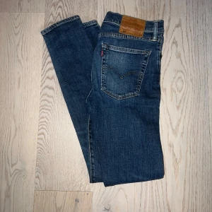 Levi's 519 smala jeans blå - Säljer ett par blå Levi's 519 jeans med smal passform. Klassisk femficksmodell med läderpatch bak och röd Levi's-tagg på bakfickan. Jeansen har normal midja och raka ben, tillverkade i slitstarkt denimtyg.