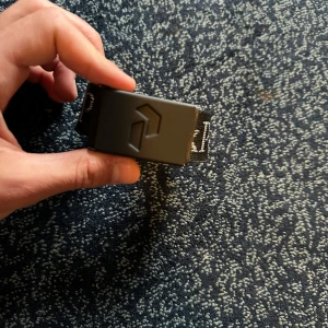 Svart bälte från Peak Performance - Säljer ett svart bälte från Peak Performance med tydlig logga längs hela bandet och en robust svart spänne. Bältet är i textilmaterial och passar perfekt till jeans eller andra byxor. Snygg och stilren accessoar för att lyfta din outfit.
