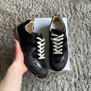 Maison Margiela Gats - Tja! 👋  Dags att sälja mina snygga och eftertraktade Maison Margielas, storlek 44. Skorna är i toppskick! Men det finns en liten defekt (bild 4) som inte syns när du har dem på dig, och det är lätt fixat. Hör av dig om du har några frågor/ funderingar! 