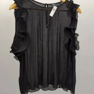 Svart blus med volang från Zara - Snygg svart plisserad blus från Zara. Ärmlös modell med stora volanger längs axlarna💕Väl omhändertagen! 