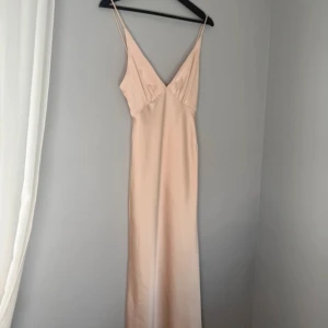 Balklänning - En superfin balklänning i champagne färg, använd endast 1 gång! Banden är uppsydda då dem va lite långa men vill man ha banden längre så går det enkelt att sprätta up!