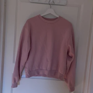 Ljusrosa sweatshirt från Gina Tricot - En basic ljusrosa sweatshirt från Gina Tricot i storlek S, från basics-kollektionen. Tröjan har rund hals, ribbade muddar och är långärmad. Perfekt för en chill och avslappnad stil. Mjuk och skön bomullskänsla.