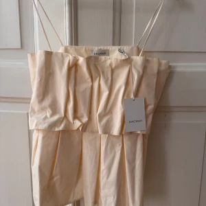 NY! Topp från Dagmar 38 - Ny med tagg. Säljer pga för stor för mig. Superfin topp med skulptural silhuett och tunna axelband. Färg: cream white   Nypris är ca 3000 kr.