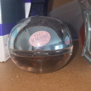 DKNY Be Delicious Fresh Blossom parfym - Säljer en DKNY Be Delicious Fresh Blossom parfym i en rund, äppelformad flaska av genomskinligt glas med rosa etikett. Doften är fräsch och blommig, perfekt för dig som gillar lätta och feminina parfymer. Flaskan har en silvrig spraytopp. Parfymen är endast sprejat ett par enstaka gånger så är nästan full! Köptes för 280 kr 