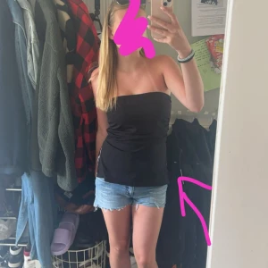 Svart bandeau tubtopp från 157 - Svart bandeau tubtopp från 157 i stretchigt och mjukt material. Toppen är axelbandslös och har en enkel, clean look med dubbelt tyg framtill för extra komfort. Den har slits nedtill i sidan. Perfekt för lager-på-lager eller som den är till jeans eller kjol.