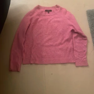 Rosa stickad tröja från Vero Moda - Mysig rosa stickad tröja från Vero Moda i storlek S. Tröjan har rund halsringning, långa ärmar och ribbade muddar vid hals, ärmslut och nederkant. Perfekt för lager-på-lager och enkel att styla med jeans eller kjol.