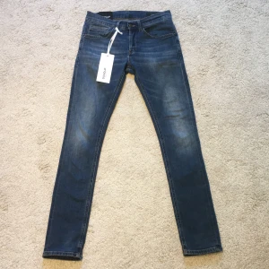 Dondup George - Snygga blå skinny jeans från George med klassisk femficksdesign och orangea sömmar. Jeansen har en smal passform och är tillverkade i stretchigt denimtyg för extra komfort. Perfekta för dig som gillar en tajt siluett och stilren look.