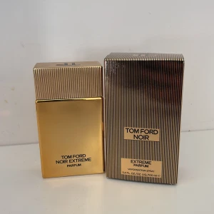 Tom Ford Noir Extreme Parfum 100ml - Lyxig parfym från Tom Ford i modellen Noir Extreme. Flaskan är rektangulär och helblank i guld med matchande guldask med svarta ränder. Doften är intensiv och elegant, perfekt för dig som gillar exklusiva och djupa parfymer.
