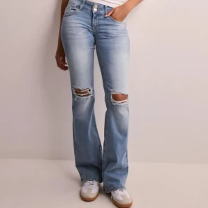 Ljusblå bootcut jeans  - De populära snygga ljusblå bootcut jeansen med hål över knäna från Nelly som är slutsålda. Aldrig använt jeansen så dom är vid nyskick💕 