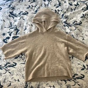 Beige stickad hoodie från Lindex - Mysig beige stickad hoodie från Lindex med kortare ärmar och ribbad kant nertill. Perfekt för lager-på-lager och chill dagar. Oversized känsla och skön huva för extra comfort. Står att det är storlek 140 men passar perfekt för mig som har storlek 170.❤️
