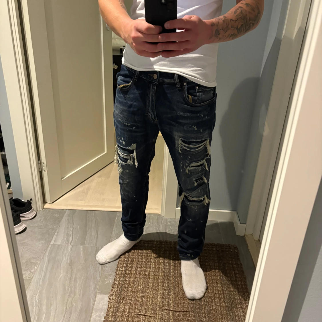 Mörkblå ripped jeans från HESNTLS