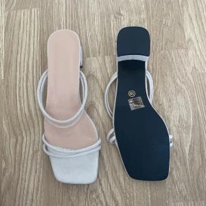 Beiga sandaler med blockklack och remmar - Stilrena sandaler i beige mocka med fyrkantig tå och blockklack. Skorna har dubbla tunna remmar över foten och öppen häl, vilket ger en trendig och minimalistisk look. Perfekta för varma dagar och snygga till jeans eller klänning. Helt nya aldrig använt, orsak till att jag säljer är för att de var för stora.💕