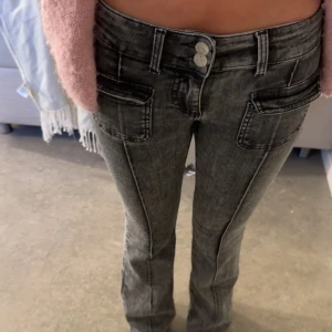 Grå jeansbyxor från Nelly - Snygga grå jeansbyxor från Nelly med tvättad look och dubbla silverknappar i midjan. Strl 32. 