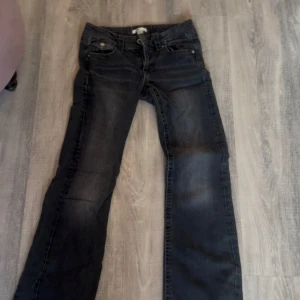 Svarta jeans från Gina Tricot, stl 158 - Snygga svarta jeans från Gina Tricot i storlek 158. Jeansen har klassisk femficksdesign, dragkedja och knapp framtill samt diskreta slitningar för en cool look. Perfekta till vardags med en hoodie eller t-shirt.