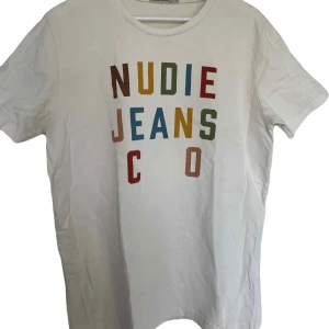 Nudie Jeans T Shirt - Vit t-shirt från Nudie Jeans Co. Stilrent tryck på framsidan, perfekt sommartisha. Storlek M, hör av dig med prisförslag eller frågor⭐️