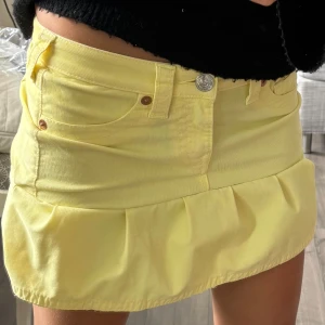 Gul jeanskjol från True Religion - Säljer en ljusgul kort jeanskjol som jag gjort själv men märket är True Religion den har en snygg volang nertill och klassiska jeansfickor både fram och bak. Kjolen har coola loggor på bakfickan. Och perfekt för dig som vill sticka ut i sommar med din egna look! Hör alltid av er vid frågor, priset kan diskuteras💕