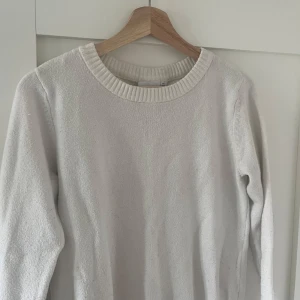 Vit stickad tröja från VILA - Säljer en enkel och stilren vit stickad tröja från VILA. Tröjan har rund halsringning med ribbad kant och långa ärmar. Perfekt att matcha med jeans eller kjol för en clean look.