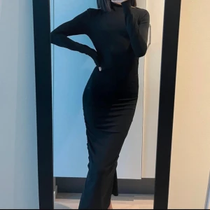 Svart långärmad klänning från DAY Birger et Mikkelsen - Säljer en svart, figurnära långklänning från DAY med lång ärm och hög hals. Använt en gång.