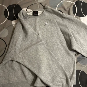 Grå Jordan sweatshirt loose fit - Snygg grå sweatshirt från Jordan med klassisk Jumpman-logga broderad på bröstet. Tröjan har loose fit, rund halsringning och långa ärmar.Perfekt för en chill och sportig stil. Mjuk insida och enkel design som funkar till det mesta. Ordinarie pris: 500kr