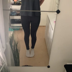 Svarta träningstights💓 - Svarta träningstights med smal passform och vita detaljer längs benen. Hög midja och liten dragkedjeficka bak. Perfekta för löpning eller gym. Stretchigt material som sitter tight och bekvämt.🧘🏽‍♀️