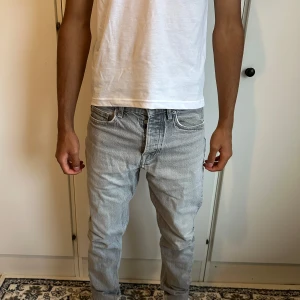 Ljusgrå jeans från Zara, storlek 36 - Säljer ett par ljusgrå jeans från Zara i klassisk femficksmodell. Jeansen har rak passform och normal midja, tillverkade i bomull med snygg tvättad look. Perfekta för en clean och avslappnad stil.