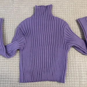 Lila ribbad polotröja från C.W. - Superfin lila polotröja från C.W. i ribbstickad modell. Tröjan har hög krage och långa ärmar. Den är stretchig. Oanvänd. Storlek xs