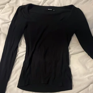 Svart långärmad topp från Bik Bok - Säljer en svart långärmad topp från Bik Bok i storlek XS. Toppen har en tight passform, rundad halsringning och är tillverkad i ett stretchigt, ribbat material som sitter snyggt på kroppen. Perfekt att styla med jeans eller kjol.