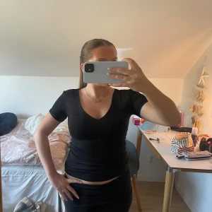 Tajt topp - En svart, tight topp med v-ringning och korta ärmar. Säljer pågrund av ingen användning. Tröjan har aldrig blivit använd💕tveka inte med att skriva om du har några frågor eller är intresserad 