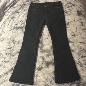 Svarta kickflare jeans från Vila - Svarta kickflare jeans från Vila med klassisk femficksdesign. Byxorna har utsvängda ben och normal midja. Materialet är en mix av bomull, polyester och elastan för en skön stretchig känsla. Perfekta för dig som gillar en trendig siluett.