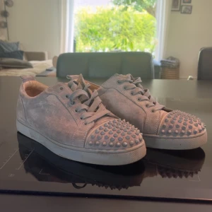 Christian Louboutin junior spikens cap-toe - Ett par riktigt fina Louboutin skor med en liten nyans av ljusblå vid spikarna och snörena. Skorna är under helt okej skick och har mycket att ge. En spik är borta och 2 andra lite skadade men det syns ej. Även ett snöre är av på toppen. Kan vara väldigt flexibel vid snabba affär👍