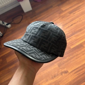 Fendi keps - Tja! Säljer en sjukt snygg Fendi keps i färgen svart. Den ger din outfit en lyxig touch, passar både till vardag och fest. Skick: 10/10 aldrig använd och tags finns. Storlek: Onezise men går att justera. Pris: 799kr. Pris kan diskuteras vid snabb affär💨. Kom DM vid fler bilder eller funderingar🥰