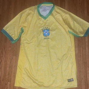 Brasilien fotbollströja nummer 10 - Gul Brasilien fotbollströja med gröna detaljer och nummer 10 på ryggen. Köpt den i Brasilien och den är helt oanvänd.