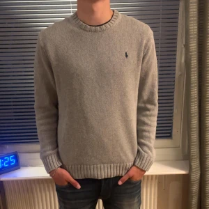 Grå tröja från Polo Ralph Lauren - Grå stickad tröja från Ralph Lauren. Skick 8/10 inga defekter men väldigt använd. Modellen är 185 och väger 74. Storlek xs men uttöjd till M. Skriv flr frågor eller liknande!