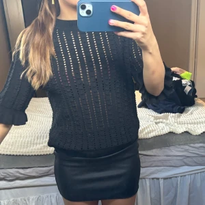 Stickad svart topp med hål - Stickad svart topp med hål och volanger vid ärmarna. Tre kvartsärmad i strl 34 men passar mig som vanligen bär S. Från carin wester, säljes pga att den inte kommer till användning. 