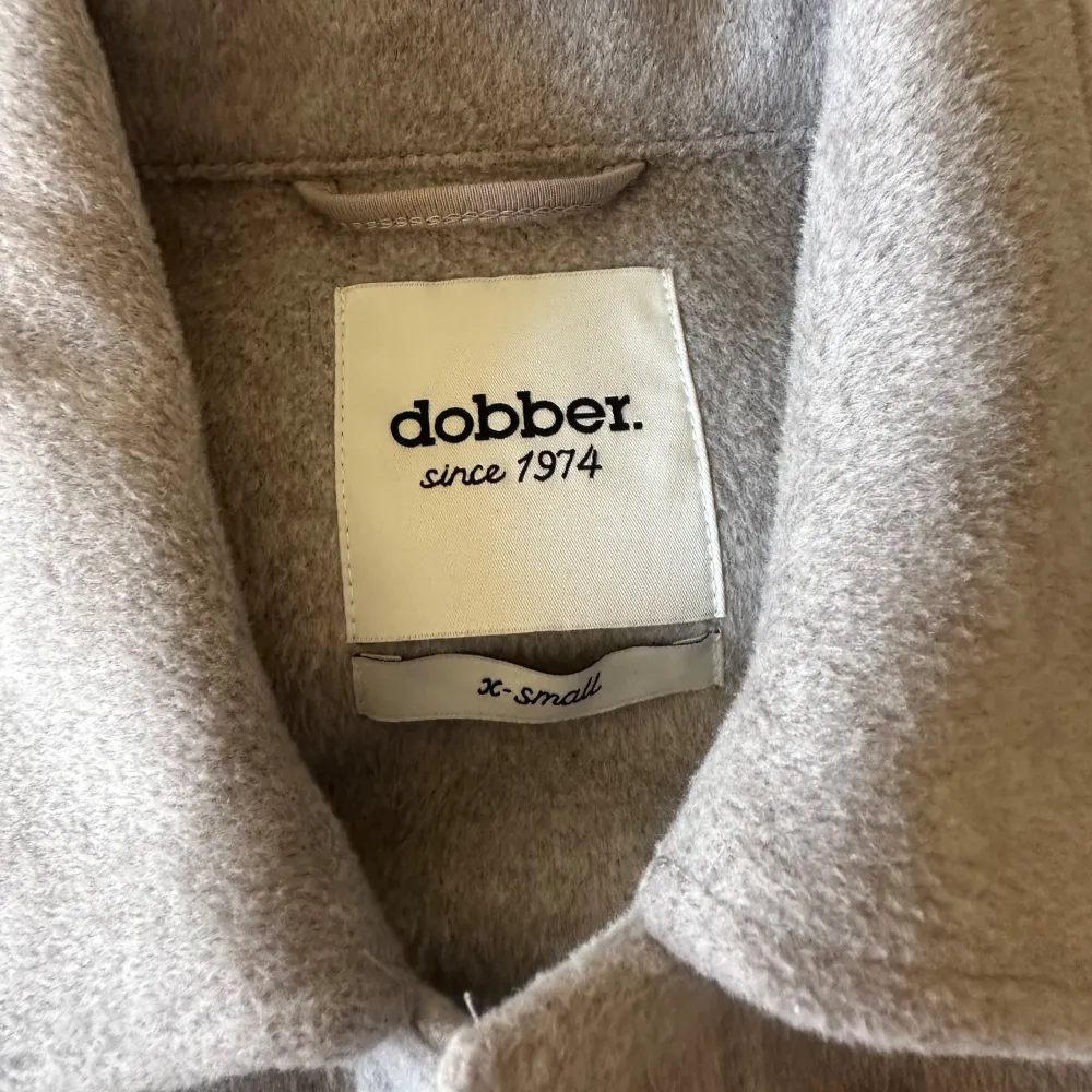 Säljer en stilren beige overshirt från Dobber i storlek XS. Den har långa ärmar och knäpps med knappar framtill. Den har en knytdetalj i midjan och två bröstfickor med lock. Använd ett fåtal gånger.. Takit.