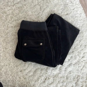 Juicy Couture byxor - Snygga svarta mjukisbyxor med fickor på baksidan från Juicy Couture med snörning i midjan. Färgen på metallen på snörena har släppt lite se på bild 4, men i övrigt bra omhändertagna och väldigt fint skick❤️Ny pris 1000kr