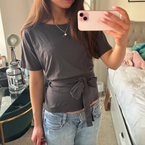 Mörkgrå topp med knytband - Perfekt topp som passar både vardag och lite finare tillfällen!