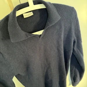 Mörkblå tröja från John Henric - Säljer en stilren mörkblå tröja från John Henric. Tröjan har en klassisk krage och långa ärmar, perfekt för en elegant look. Materialet känns mjukt och bekvämt mot huden.