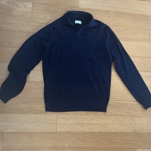 Mörkblå tröja från These Glory Days - Säljer en stilren mörkblå tröja från These Glory Days. Tröjan har en klassisk krage och är perfekt för en avslappnad men ändå uppklädd look. Passar bra till både jeans och chinos. Endast testad, men utan prislapp. 