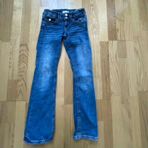 Blå jeansbyxor med bootcut - Snygga blå jeansbyxor från Gina Tricot. Byxorna har en dubbelknäppning fram och klassiska femficksdetaljer. Säljer för att de är för små❤️ storlek 146