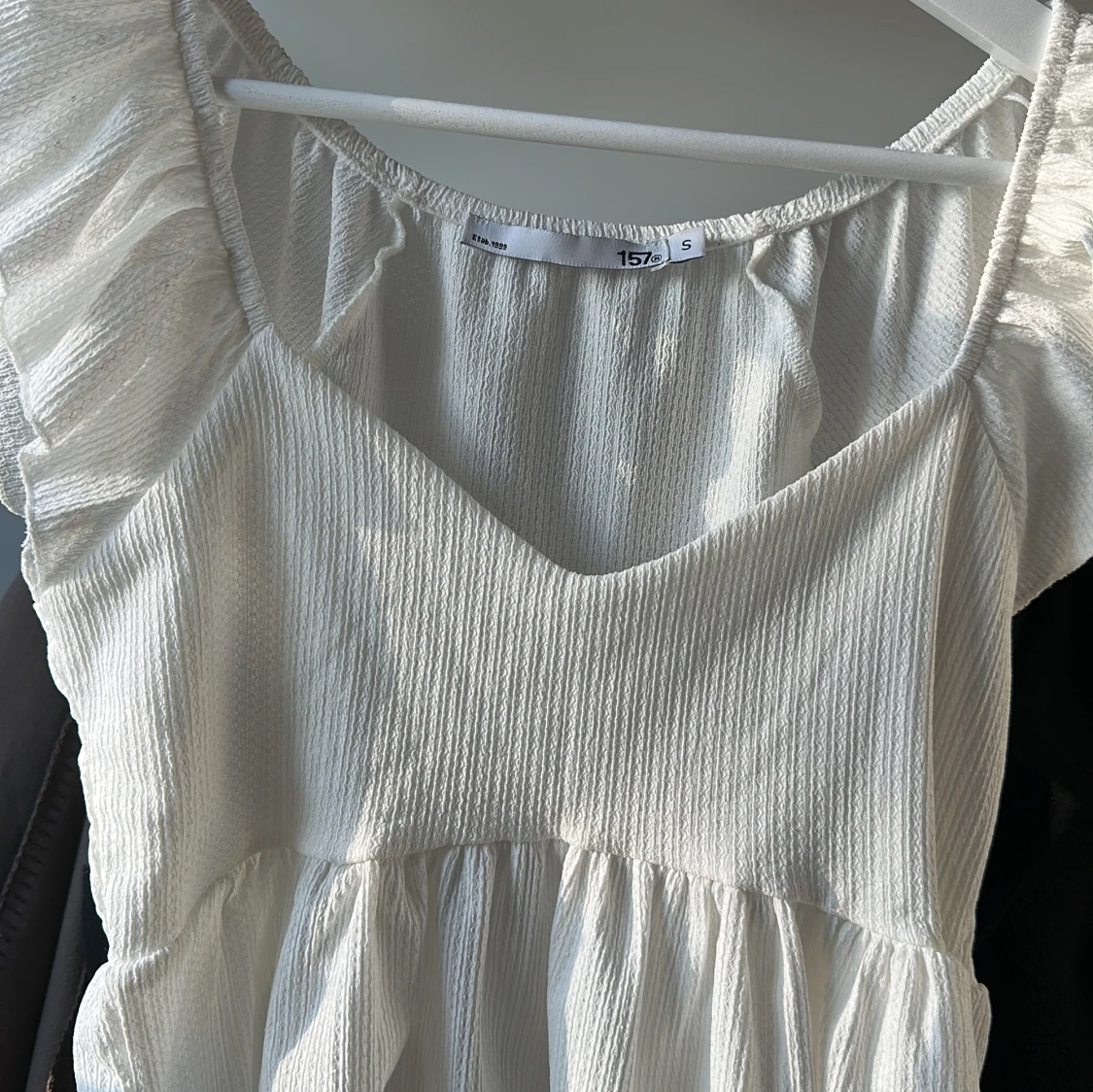 Vit ärmlös topp med volangdetaljer - 1