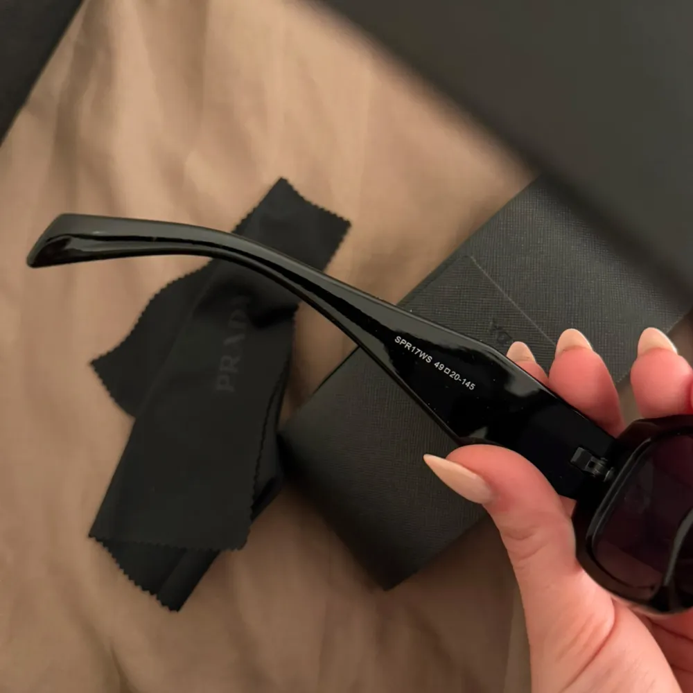 Snygga svarta solglasögon från Prada med en elegant och modern design. Inga defekter eller tecken på användning. Modellen heter PR 17WS. Asusteet.
