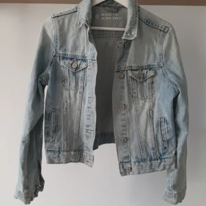 Ljusblå jeansjacka från Cubus - Säljer min älskade ljusblå jeansjacka från Cubus som tyvärr blivit för liten. Jackan har knappar framtill och två bröstfickor med knappstängning. Snyggt distressad på vissa delar, croopad modell o i 100% bomull 🧥💛 Storlek 34 men passar xxs-s 