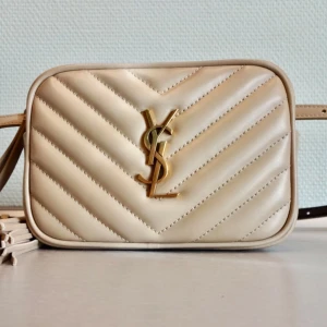 Saint Laurent Leather Lou Belt Bag -  Saint Laurent Lou Belt Bag in dark beige color. Even though it’s a belt bag but you can definitely use this as a crossbody bag. You can also take off the belt and use this bag as a clutch.  Dimension : 15 x 10 x 5.5 cm / 6 x4 x 2 inches.   The belt is around 122 cm /48 inches long  It will be delivered together with dust bag and authenticity card.