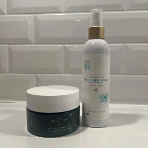 Body Scrub och Refreshing Spray från Rituals - Säljer en avslappnande body scrub och en uppfriskande spray från Rituals. Body scrubben kommer i en stilren burk med vit lock och är perfekt för att exfoliera huden. Refreshing sprayen har en fräsch doft och kommer i en praktisk sprayflaska med gulddetaljer. Perfekt för en lyxig hemmaspa-upplevelse!