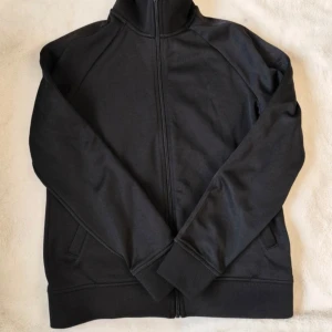 Svart jacka från Peak Performance - Säljer en stilren svart jacka från Peak Performance. Jackan har en dragkedja framtill och är långärmad. Perfekt för en sportig look eller en avslappnad dag ute. Storlek S.